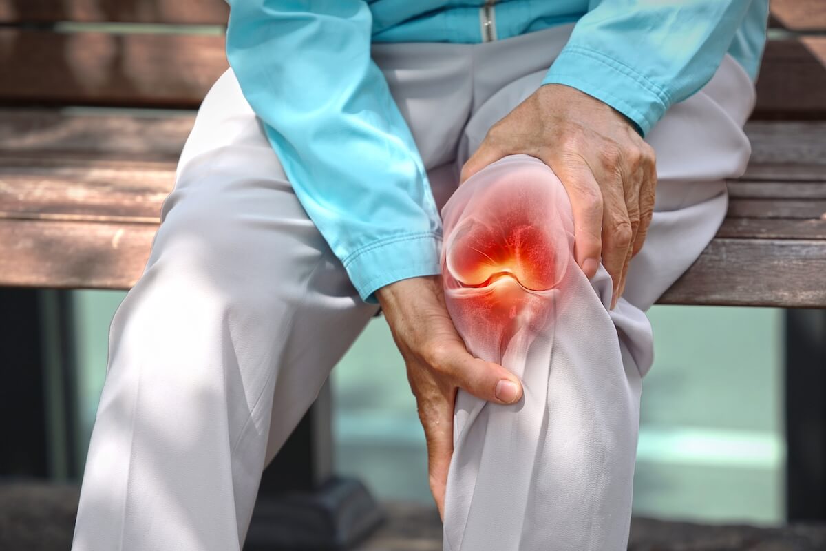 Close up of elderly woman holding knee with pain due to degenerative arthritis