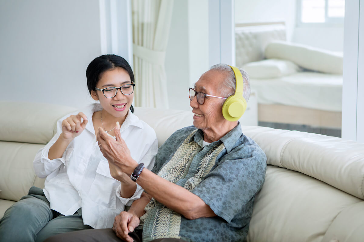 Caregiver using music therapy on a senior.