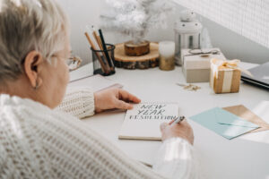 Older woman enlisting her New Year's resolutions